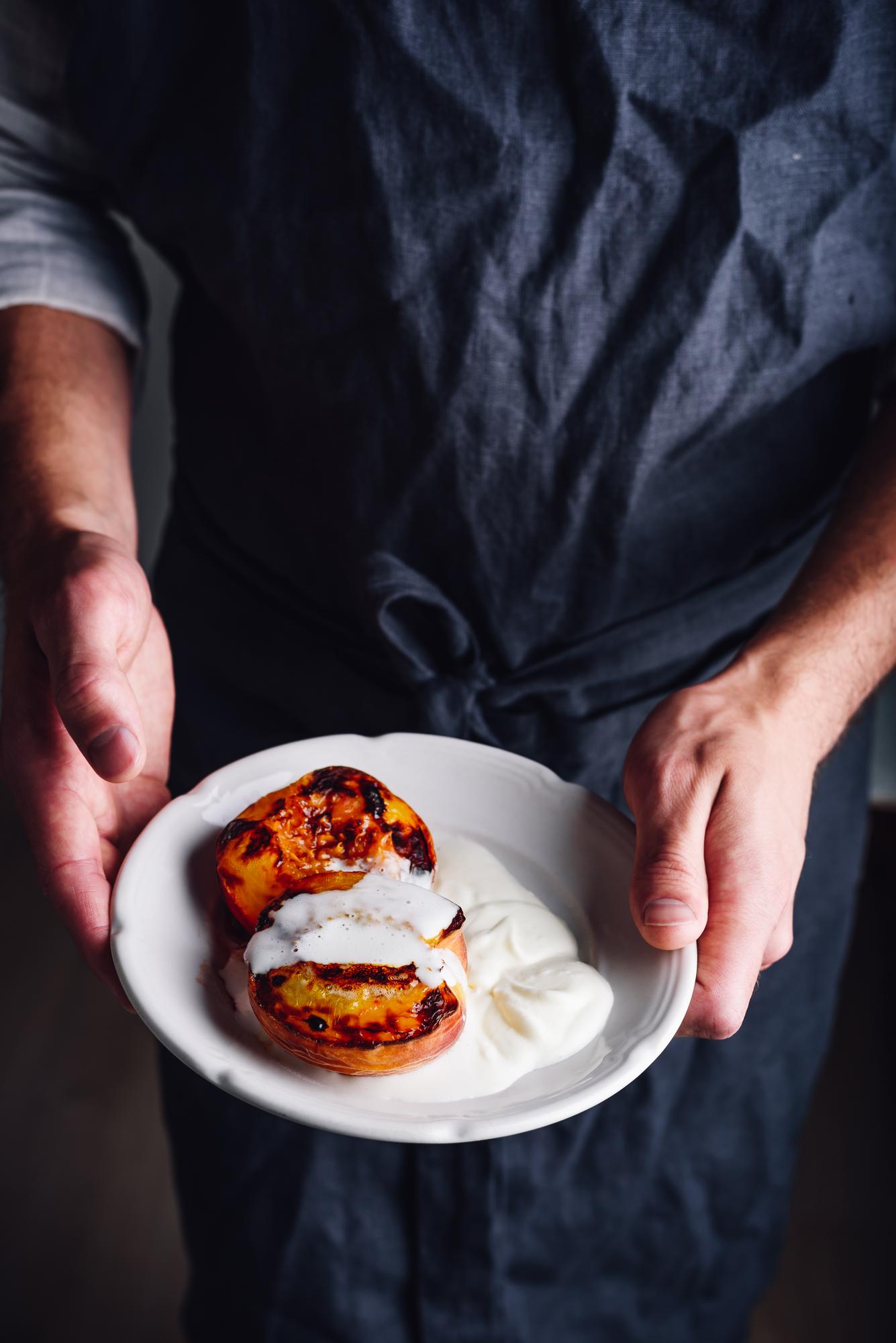 Chef plating a rustic dish in a warm kitchen
